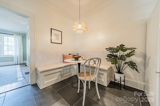 dining room with crown molding, breakfast area, and dark tile patterned flooring