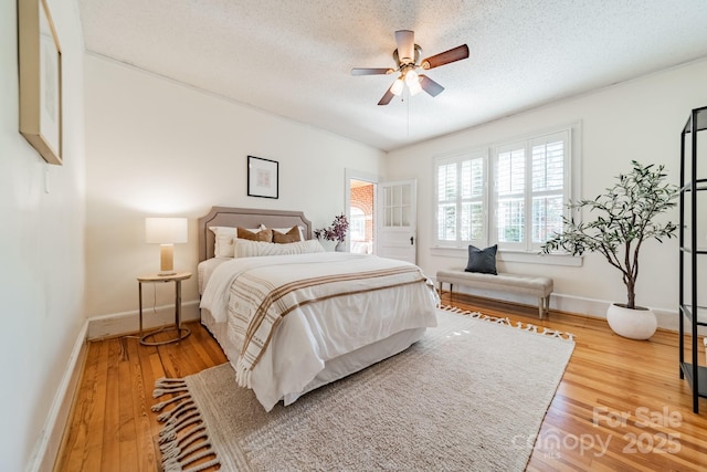 bedroom with wood-type flooring, a textured ceiling, and ceiling fan