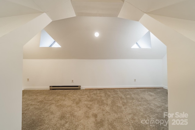 bonus room with carpet, lofted ceiling with skylight, and a baseboard heating unit