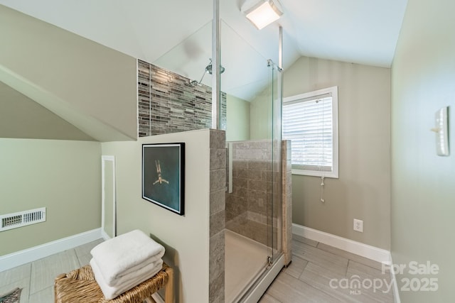 bathroom with vaulted ceiling and a shower with shower door