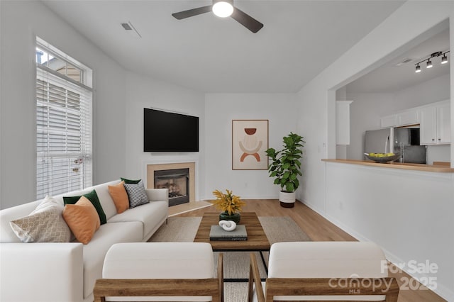 living room featuring light hardwood / wood-style flooring and ceiling fan