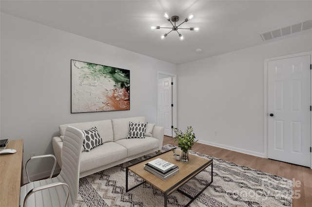 living room with hardwood / wood-style floors and an inviting chandelier