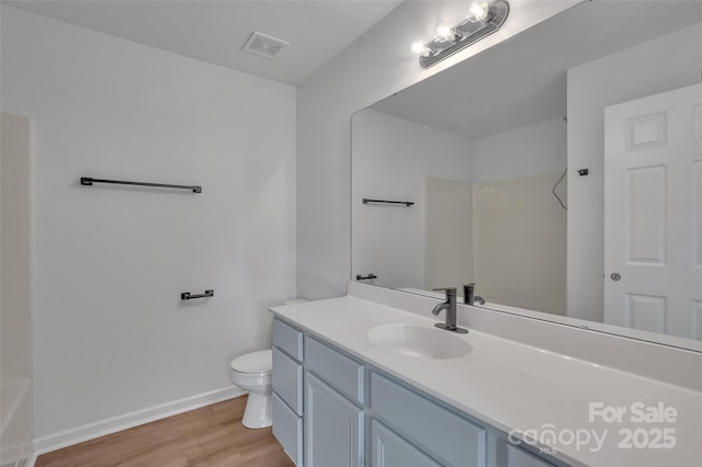 bathroom with hardwood / wood-style floors, vanity, and toilet