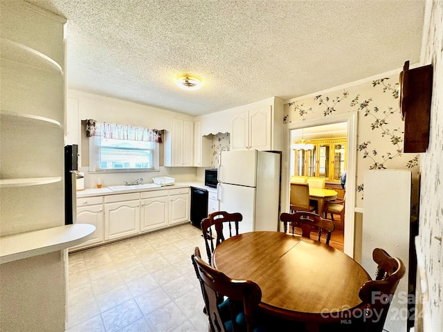 kitchen with black appliances, white cabinetry, a textured ceiling, and sink