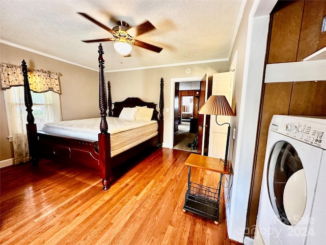 bedroom with ceiling fan, ornamental molding, a textured ceiling, washer / clothes dryer, and hardwood / wood-style flooring