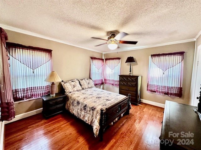 bedroom with ornamental molding, ceiling fan, hardwood / wood-style floors, and a textured ceiling