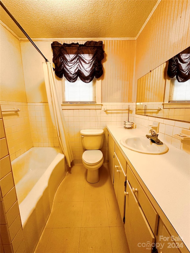 full bathroom featuring tile walls, shower / bath combo with shower curtain, a textured ceiling, toilet, and tile patterned floors