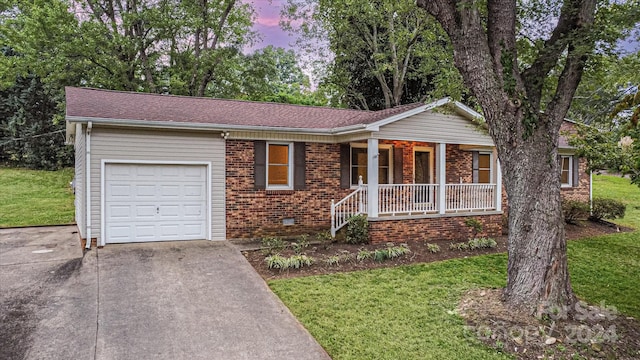 single story home featuring a lawn, a porch, and a garage