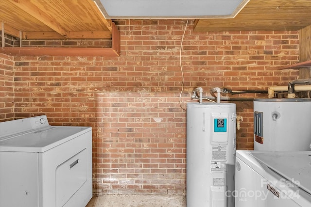 washroom featuring washer / dryer, brick wall, and electric water heater