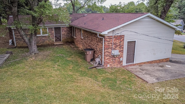 back of property with a lawn and a patio