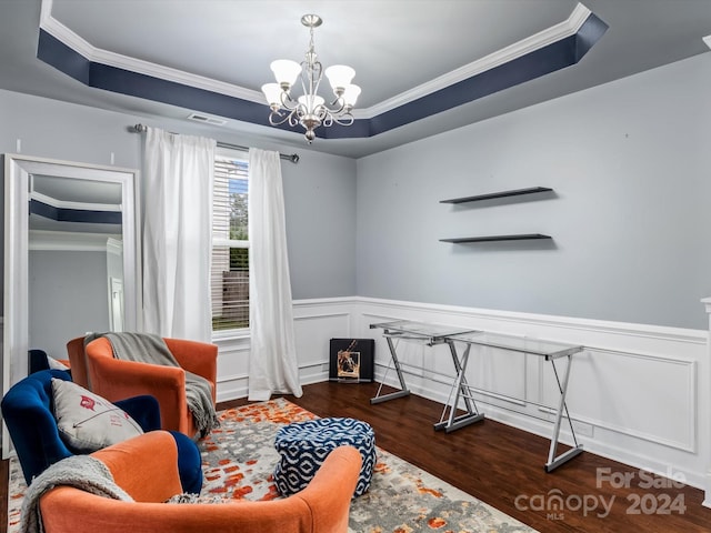 living area with ornamental molding, a notable chandelier, a raised ceiling, and dark hardwood / wood-style floors