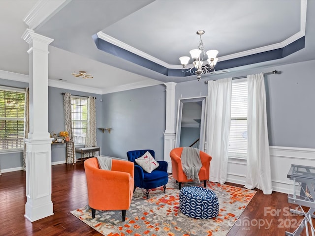 living area with a tray ceiling, dark hardwood / wood-style floors, crown molding, and a healthy amount of sunlight