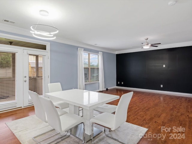 dining room featuring ceiling fan with notable chandelier, ornamental molding, and hardwood / wood-style flooring