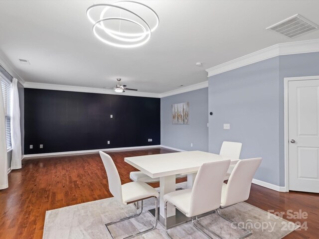 dining space with ceiling fan, ornamental molding, and dark wood-type flooring