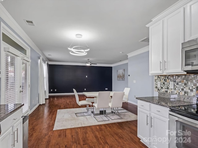 kitchen with dark stone countertops, stainless steel appliances, and white cabinets