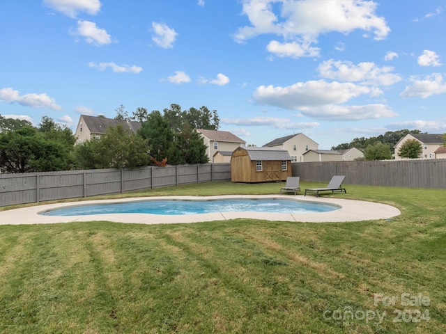 view of pool with a lawn and a storage unit