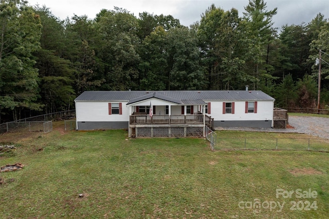 manufactured / mobile home with a wooden deck and a front yard