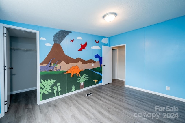 unfurnished bedroom featuring a textured ceiling and hardwood / wood-style floors