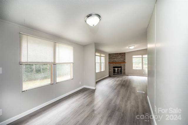 unfurnished living room with hardwood / wood-style flooring, a fireplace, and lofted ceiling