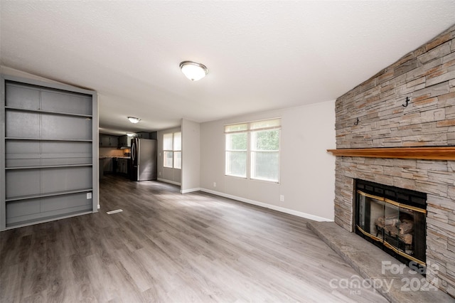 unfurnished living room with hardwood / wood-style floors, a textured ceiling, and a fireplace