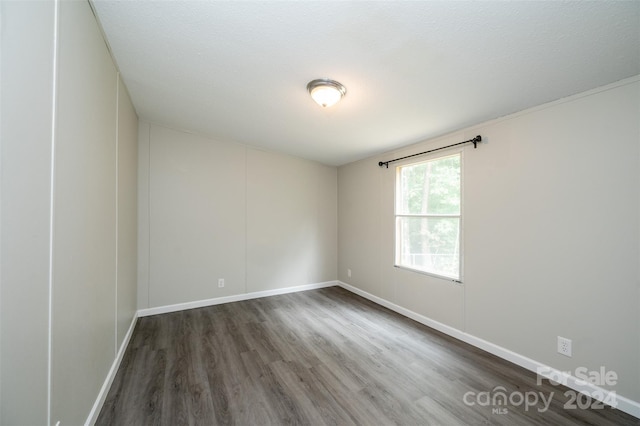 empty room with a textured ceiling and dark hardwood / wood-style floors