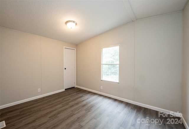 unfurnished room featuring a textured ceiling, lofted ceiling, and dark hardwood / wood-style floors