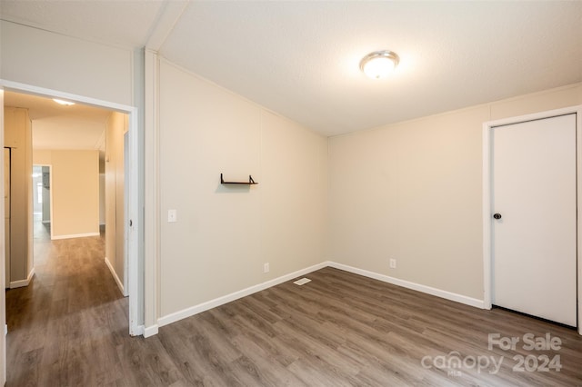 unfurnished bedroom with a textured ceiling and wood-type flooring