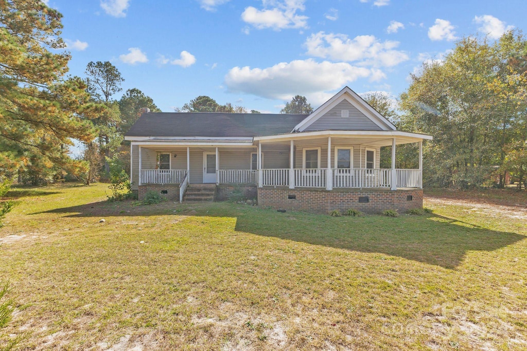 farmhouse featuring a front yard and covered porch