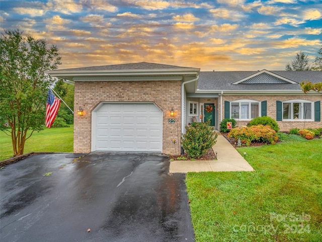 single story home with a lawn and a garage