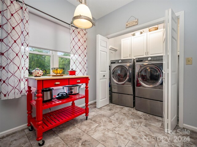 laundry room with washer and clothes dryer and cabinets