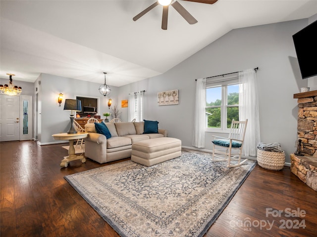 living room with ceiling fan with notable chandelier, vaulted ceiling, and dark wood-type flooring