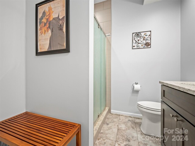 bathroom with tile patterned flooring, vanity, toilet, and an enclosed shower