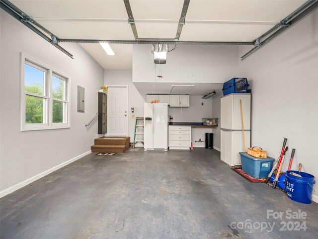 garage with a garage door opener, electric panel, and white refrigerator with ice dispenser