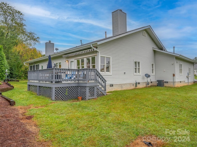 back of property featuring central AC unit, a wooden deck, and a lawn