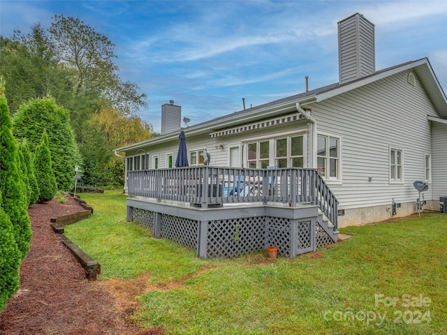 back of house featuring a deck and a yard