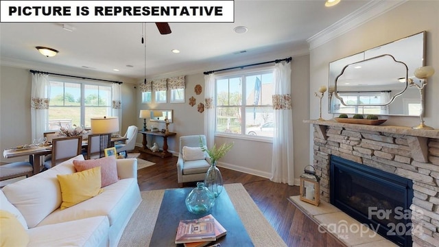 living room featuring dark hardwood / wood-style flooring, ceiling fan, a stone fireplace, and ornamental molding