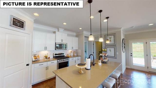 kitchen featuring white cabinetry, hanging light fixtures, an island with sink, and stainless steel appliances