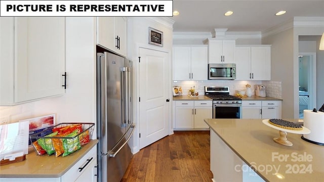 kitchen featuring backsplash, dark wood-type flooring, ornamental molding, white cabinetry, and stainless steel appliances