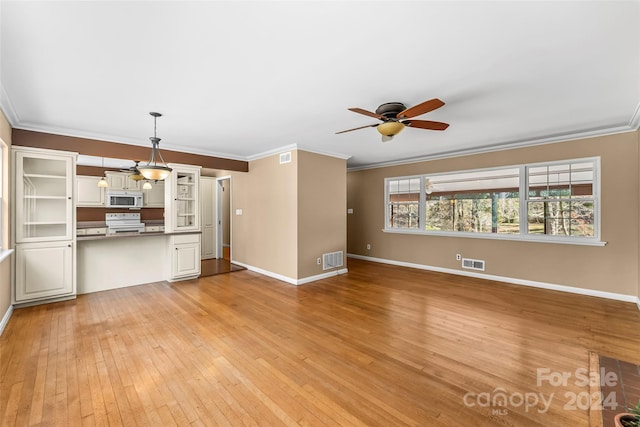 unfurnished living room featuring ceiling fan, light hardwood / wood-style floors, and ornamental molding