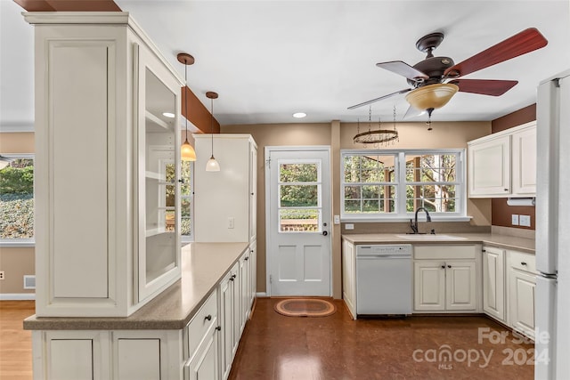 kitchen with white dishwasher, a healthy amount of sunlight, and sink