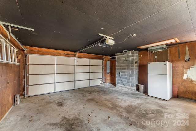 garage featuring white refrigerator and a garage door opener