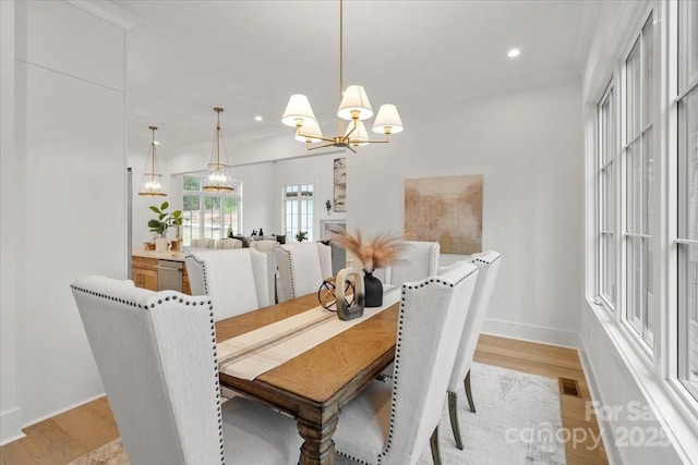 dining space with an inviting chandelier and light wood-type flooring