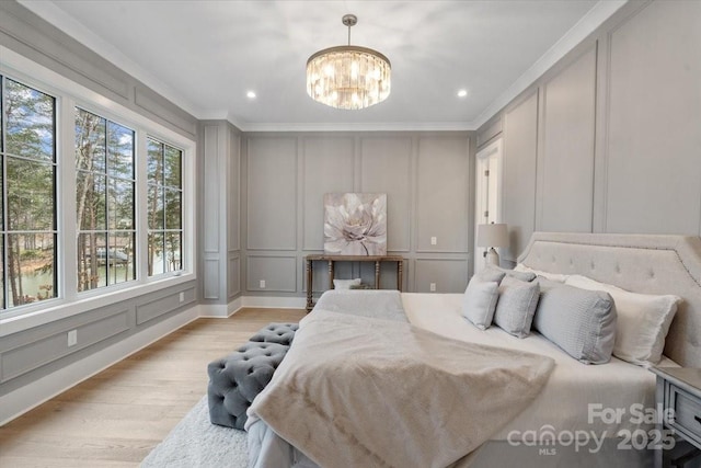 bedroom with crown molding, a notable chandelier, and light wood-type flooring