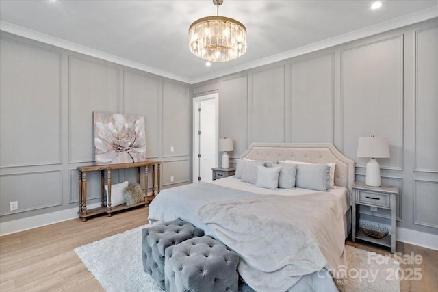 bedroom featuring ornamental molding, light hardwood / wood-style floors, and a chandelier