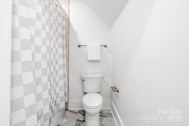 bathroom featuring a shower with curtain, toilet, and vaulted ceiling