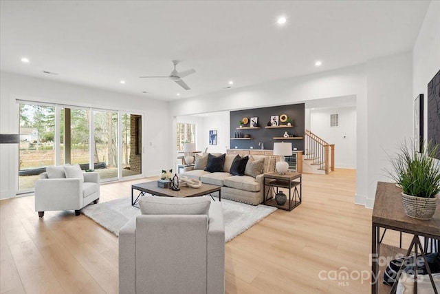 living room with ceiling fan and light wood-type flooring