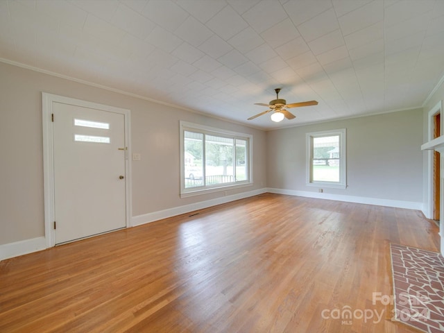 unfurnished living room featuring light hardwood / wood-style floors, ceiling fan, and crown molding