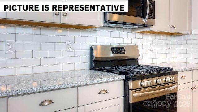 kitchen with light stone countertops, white cabinetry, appliances with stainless steel finishes, and decorative backsplash