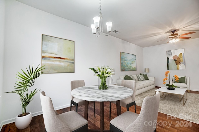 dining room featuring ceiling fan with notable chandelier and dark hardwood / wood-style floors