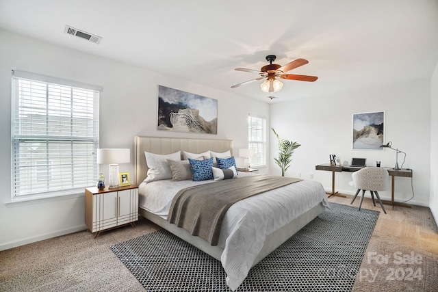 carpeted bedroom featuring ceiling fan and multiple windows